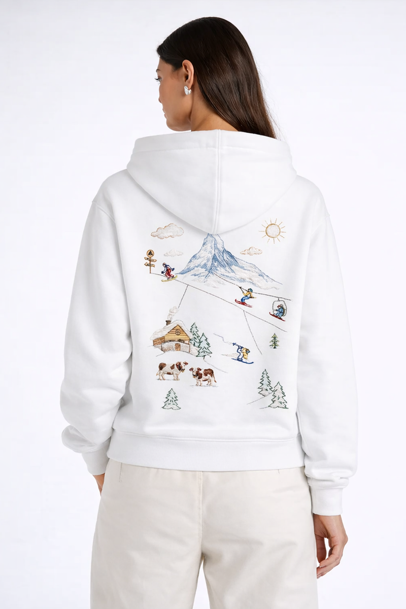 Hoodie blanc avec illustration des Alpes suisses au dos, scène de ski avec montagne, chalet et télécabine